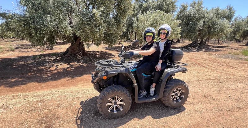 quad biposto su sentiero sterrato tra ulivi secolari a Monopoli