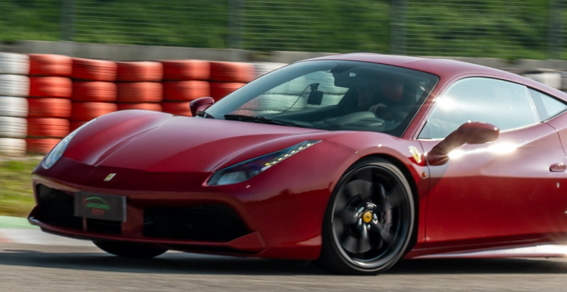 Esperienza di guida al volante della Ferrari 488 GTB rossa lungo i cordoli della Pista Azzurra