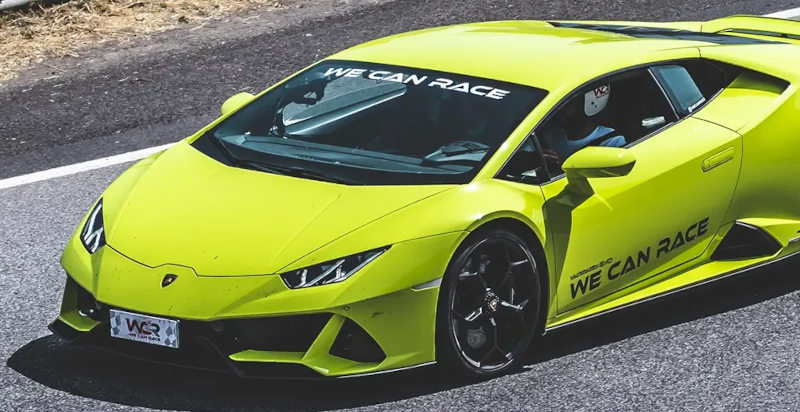 Pilota alla guida di una Lamborghini Huracán EVO in curva su circuito chiuso