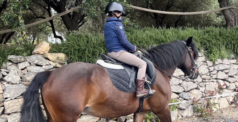 lezione di ecquitazione - ragazza sul cavallo nel parco Asinolla