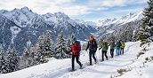 Piccolo gruppo durante una ciaspolata Val Brembana a San Simone tra boschi e montagne innevate