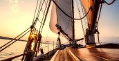 Barca a vela in navigazione sotto le falesie di Polignano a Mare