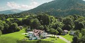 Vista esterna dello storico Rifugio Pranolz immerso nel verde dei boschi della Valbelluna